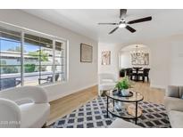 Spacious living room featuring stylish decor, a ceiling fan, and an open archway to the dining area at 6001 N 10Th Way, Phoenix, AZ 85014