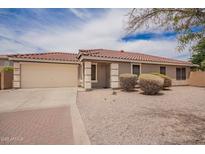 Charming single story home features a two car garage, desert landscaping, and a red tiled roof at 6085 S Wilson Dr, Chandler, AZ 85249