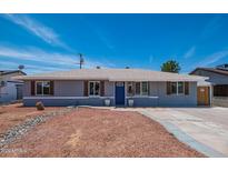 Charming single-story home featuring a blue front door, shuttered windows, and low-maintenance landscaping at 8326 N 8Th St, Phoenix, AZ 85020