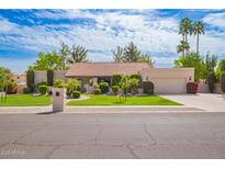 Charming single-story home with a well-manicured lawn, mature trees, and an attached two-car garage at 8851 S Juniper St, Tempe, AZ 85284