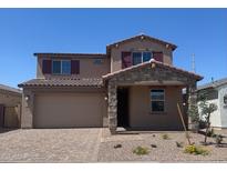 Charming two-story home featuring a stone-accented entry, paver driveway, and coordinated exterior color scheme at 16760 W Hope Dr, Surprise, AZ 85388