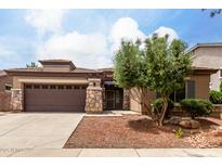 Charming single-story home with a stone-accented facade, a spacious driveway, and a well-maintained front yard at 18719 E Pelican Ct, Queen Creek, AZ 85142
