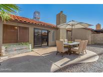 Inviting outdoor patio with dining area and lush landscaping, ideal for relaxing or entertaining guests at 2154 E Forge Ave, Mesa, AZ 85204