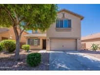 Charming two-story home featuring a two-car garage and well-manicured front yard with mature tree at 41251 W Barcelona Dr, Maricopa, AZ 85138
