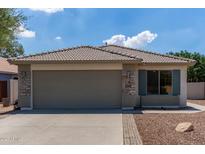 Charming single-story home featuring a tile roof, stone accents, and a two-car garage in a residential neighborhood at 4143 E Sundance Ave, Gilbert, AZ 85297