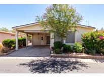 Charming single-story home featuring a carport and vibrant landscaping with flowering bushes and mature trees at 6391 S Oakmont Dr, Chandler, AZ 85249