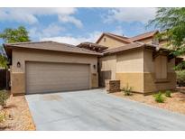Inviting exterior showcasing a beige home with a two-car garage, complemented by a well-maintained concrete driveway at 8848 W Cordes Rd, Tolleson, AZ 85353