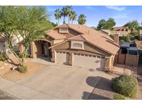 Beautiful two-story home showcasing a tile roof, manicured landscaping, and an attached three-car garage at 1015 E Constitution Dr, Gilbert, AZ 85296
