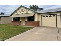 Charming single-story home with a brick accent wall and a well-manicured front lawn and a single car garage at 10201 N 97Th Ave # B, Peoria, AZ 85345