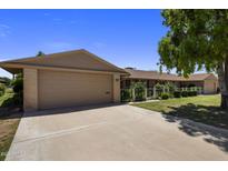 Charming single-story home with a two-car garage and well-maintained landscaping at 10325 W Prairie Hills Cir, Sun City, AZ 85351