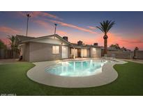 Backyard pool and patio with a lush lawn, perfect for outdoor entertaining and relaxation at 1036 S 75Th St, Mesa, AZ 85208