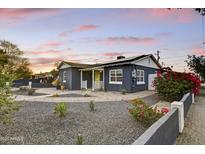 Charming home with a dark blue exterior, inviting front porch, and delightful landscape at 1444 E Coronado Rd, Phoenix, AZ 85006