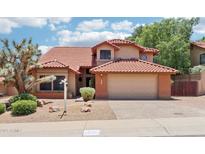 Charming home featuring a red tile roof, a two-car garage, and desert landscaping in the front yard at 1813 E Sheena Dr, Phoenix, AZ 85022