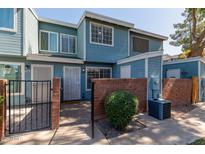 Blue two-story home featuring brick accents, gated entry and well-maintained landscaping at 2301 E University Dr # 172, Mesa, AZ 85213