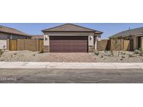 Modern home with a two car garage and decorative stone accents and a brick paver driveway at 25109 N 174Th Ln, Surprise, AZ 85387