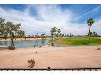 Scenic view of a golf course and a pond under a blue sky with fluffy clouds at 3441 N 162Nd Ln, Goodyear, AZ 85395