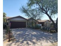 Charming single-story brick home featuring a two-car garage, desert landscaping, and a well-maintained front yard at 402 E Claremont St, Phoenix, AZ 85012