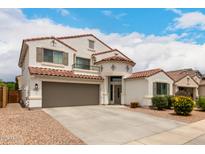 Beautiful two-story home featuring a red tile roof, a two-car garage, and a well-manicured front yard with lush landscaping at 4142 E Sandy Way, Gilbert, AZ 85297