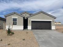 Charming single-story home features a gray stucco exterior, a dark brown garage door, and low maintenance landscaping at 1359 S Vista Ave, Florence, AZ 85132