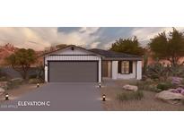 Charming single-story home featuring a gray garage door and drought-resistant landscaping at 17095 N Lariat Rd, Maricopa, AZ 85138