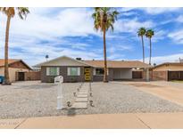 Charming home with desert landscaping, sidewalk, and a yellow front door provides excellent curb appeal at 2821 E Larkspur Dr, Phoenix, AZ 85032
