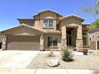 Inviting home featuring stone accents, a two-car garage, and low-maintenance desert landscaping in front yard at 33506 N 24Th Dr, Phoenix, AZ 85085