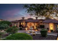 Stunning home exterior featuring a stone facade, fountain, and professional landscaping at twilight at 4328 N Pinnacle Ridge Cir, Mesa, AZ 85207