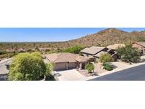 Desert home boasts lush trees, multi-car garage, and gorgeous desert mountain views at 4562 S Alamos Way, Gold Canyon, AZ 85118