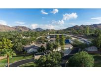 Expansive estate with mature landscaping, a tennis court, and mountain views on a sunny day at 4801 E Horseshoe Rd, Paradise Valley, AZ 85253