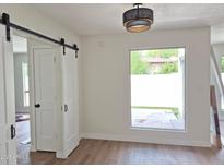 Bright bedroom with a window view to backyard and sliding barn doors to closet and en-suite bathroom at 5308 N 2Nd Ave, Phoenix, AZ 85013