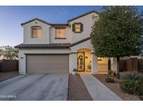 Charming two-story home featuring a well-manicured lawn, two car garage and tile roof at 12110 W Rowel Rd, Peoria, AZ 85383