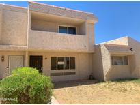 Two-story tan townhome featuring desert landscaping, patio, and a brown roof at 2155 W Farmdale Ave # 8, Mesa, AZ 85202