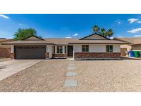 Charming single-story home with desert landscaping, complemented by a two car garage and palm trees at 2348 E Diamond Ave, Mesa, AZ 85204