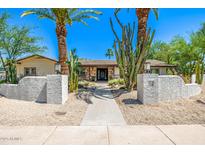 Charming home featuring a desert landscape with palm trees and a stone walkway leading to the front door at 28 E Winged Foot Rd, Phoenix, AZ 85022