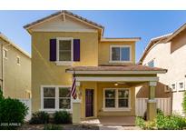 Charming yellow two-story home with a covered porch and well-maintained front yard at 3085 E Camellia Dr, Gilbert, AZ 85296