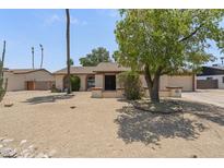 Charming single-story home with desert landscaping, mature tree, and an inviting facade at 4535 E Redfield Rd, Phoenix, AZ 85032