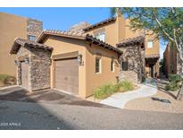 Beautiful home exterior showcasing stone accents, a two-car garage, and well-maintained landscaping at 6145 E Cave Creek Rd # 203, Cave Creek, AZ 85331