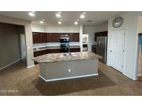 Kitchen featuring dark cabinets and granite countertops with a large center island at 7580 W Darrel Rd, Laveen, AZ 85339