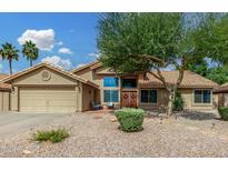 Charming single-Gathering home with a spacious two-car garage, desert landscaping, and a beautiful tree in the front yard at 9004 S Ash Ave, Tempe, AZ 85284