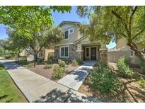 Charming two-story home featuring a stone facade, manicured landscaping, and inviting entrance at 970 S Henry Ln, Gilbert, AZ 85296
