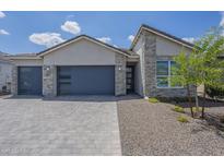 Beautiful single-Gathering home featuring stone accents, paver driveway, and a modern garage door at 10509 W Harmony Ln, Peoria, AZ 85382