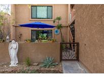 Charming courtyard view with desert landscaping, seating area with a blue umbrella, and artistic decor at 16233 E Rosetta Dr # 47, Fountain Hills, AZ 85268