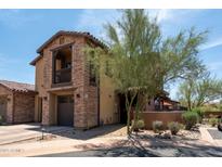 Two-story home with a stone facade, balcony, and well-maintained landscaping at 17665 N 93Rd Way, Scottsdale, AZ 85255