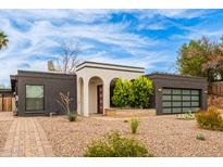 Charming single-story home featuring unique architectural details and desert landscaping, a modern garage door and drought tolerant plantings at 2033 E Janice Way, Phoenix, AZ 85022