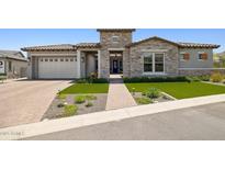 Beautiful single-Gathering home featuring a well-manicured lawn, brick driveway, and stone accents at 20797 W Rattler Rd, Buckeye, AZ 85396
