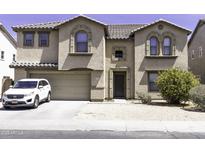 Inviting two-story home with a neutral-toned exterior, arched windows, attached two-car garage, and well-kept landscaping at 25574 W Lynne Ln, Buckeye, AZ 85326