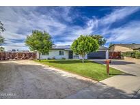 Charming single-story home featuring manicured landscaping, solar panels, and a spacious driveway at 4162 W Sierra St, Phoenix, AZ 85029
