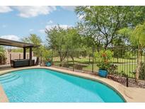 Sparkling pool featuring golf course views, privacy fence, and mature landscaping at 5029 S Carlyle Dr, Gilbert, AZ 85298