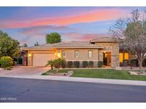 Beautiful single-story home featuring manicured landscaping, a paver driveway, and a two-car garage at sunset at 5291 S Bradshaw Pl, Chandler, AZ 85249