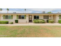Charming home with green shutters, lush landscaping, and well-maintained front lawn at 9265 N 111Th Ave, Sun City, AZ 85351